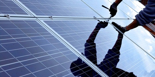 Elinstallatör speglas i solpanelen.